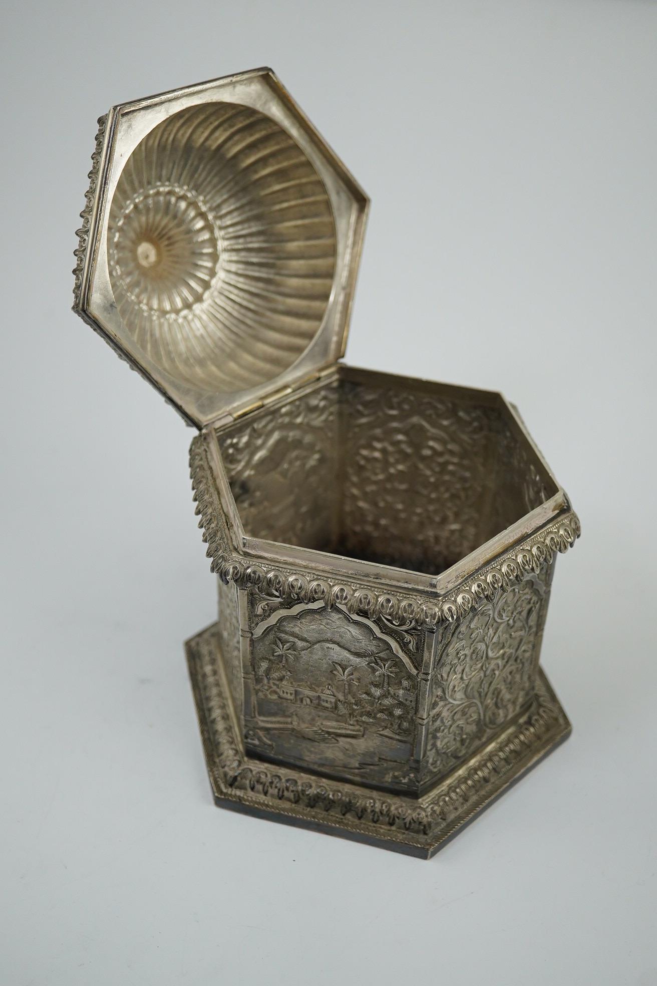 An early 20th century Indian embossed silver hexagonal box with fluted domed hinged cover